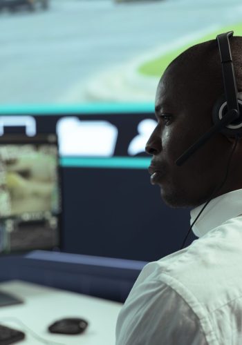 African american guy supervising traffic activity via CCTV system, using surveillance footage and radar in the city. Control center employee tracking cars through security cameras.